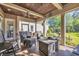 Relaxing screened porch with comfortable seating, ceiling fan, and garden views at 107 Long Bay Golf Pl., Longs, SC 29568