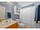 Neutral bathroom features a white shower curtain, toilet, and storage above with vanity cabinet at 1117 Jumper Trail Circle, Myrtle Beach, SC 29588