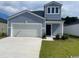Charming two-story home with blue siding, attached garage and well-maintained lawn at 1166 Silver Perch Place, Sunset Beach, NC 28468