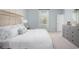 Tranquil main bedroom with neutral tones, large windows and dresser storage at 1166 Silver Perch Place, Sunset Beach, NC 28468