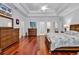 Primary bedroom featuring hardwood floors, tray ceiling, and access to an ensuite bathroom at 120 Whitemarsh Ct., Murrells Inlet, SC 29576