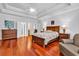 Primary bedroom featuring hardwood floors, tray ceiling, and a decorative ceiling fan at 120 Whitemarsh Ct., Murrells Inlet, SC 29576
