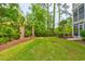 The home's grassy backyard features a palm tree, mature trees and lush plantings at 128 Puffin Dr. # 1-E, Pawleys Island, SC 29585
