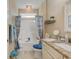 Well-lit bathroom with a granite countertop vanity, shower with curtain, and neutral decor at 128 Puffin Dr. # 1-E, Pawleys Island, SC 29585