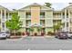 Inviting multi-story condo building featuring multiple units, well-maintained landscaping, and ample parking at 128 Puffin Dr. # 1-E, Pawleys Island, SC 29585