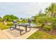 View of a picnic table and two grills adjacent to a small pond with nearby neighborhood homes at 128 Puffin Dr. # 1-E, Pawleys Island, SC 29585