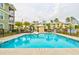 Large community swimming pool surrounded by lounge chairs and lush landscaping for a relaxing setting at 128 Puffin Dr. # 1-E, Pawleys Island, SC 29585