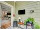 Covered porch area with a TV, mini fridge and outdoor seating at 128 Puffin Dr. # 1-E, Pawleys Island, SC 29585