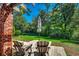 Private backyard area with mature trees, wooden chairs, and outdoor umbrella at 141 N Gate Rd., Myrtle Beach, SC 29572