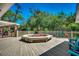 Large wooden deck featuring a flower-filled fire pit with a fenced-in backyard and mature trees at 141 N Gate Rd., Myrtle Beach, SC 29572