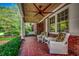 Charming brick home with a covered front porch featuring wicker furniture and a ceiling fan at 141 N Gate Rd., Myrtle Beach, SC 29572