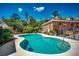 Inviting pool with a pool cleaner surrounded by a brick house, trees, and green landscaping at 141 N Gate Rd., Myrtle Beach, SC 29572