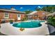 Large pool with a brick house and outdoor seating surrounded by mature landscaping at 141 N Gate Rd., Myrtle Beach, SC 29572
