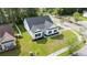 Aerial view of a bright, white home with a dark roof, surrounded by a green lawn and mature trees at 1500 Sunmeadow Dr., Conway, SC 29526