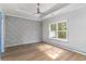 Bedroom features a modern accent wall, ceiling fan, and a large window at 1500 Sunmeadow Dr., Conway, SC 29526