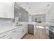 Bright kitchen features white cabinets, stainless steel appliances, quartz countertop, and marble backsplash at 1500 Sunmeadow Dr., Conway, SC 29526