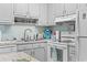 Bright kitchen featuring white appliances and cabinets with a tiled backsplash at 1502 Yaupon Dr. # A-1, Myrtle Beach, SC 29577