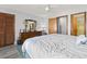 Main bedroom with ceiling fan, wooden closet, and doors leading to an en suite bathroom at 1502 Yaupon Dr. # A-1, Myrtle Beach, SC 29577