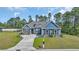 Charming blue two-story home with manicured lawn and lush trees in the background at 1509 Osage Dr., Myrtle Beach, SC 29579