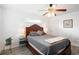Bright bedroom features a wood-frame bed, ceiling fan, and neutral decor, offering a calm and inviting atmosphere at 175 Cypress Ln., Little River, SC 29566