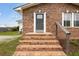 Charming brick home entrance with a gray front door at 175 Cypress Ln., Little River, SC 29566