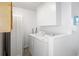 Clean laundry room features white cabinetry and appliances, providing a functional and organized space at 175 Cypress Ln., Little River, SC 29566