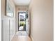 Open entryway with wood flooring and white wall panels leads to a bright view of the home's front lawn and charming exterior at 179 S Reindeer Rd., Surfside Beach, SC 29575