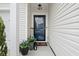 A charming entrance to a home with a welcoming black door, stylish lighting, and decorative plants to enhance curb appeal at 179 S Reindeer Rd., Surfside Beach, SC 29575
