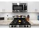 Gas range with stainless steel microwave and granite countertops, offering a modern look at 179 S Reindeer Rd., Surfside Beach, SC 29575