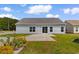 A cozy backyard features a concrete patio and well-maintained lawn, perfect for outdoor relaxation at 207 Cupola Dr., Longs, SC 29568