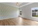 Bright bedroom with natural light, a wallpaper accent, and wood flooring at 207 Cupola Dr., Longs, SC 29568