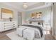 Cozy bedroom featuring stylish wallpaper, a tray ceiling, and comfortable furnishings at 207 Cupola Dr., Longs, SC 29568