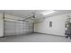 Spacious garage with a sectional door, utility connections, and overhead lighting at 207 Cupola Dr., Longs, SC 29568