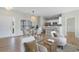 Bright, open-concept living area with hardwood floors, dining area, and views into kitchen at 207 Cupola Dr., Longs, SC 29568