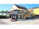 Beach bar exterior with a wooden deck, palm trees, vibrant flowers, and ample parking at 332 Bayou Loop # Lot 69, Surfside Beach, SC 29575