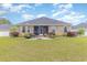 Landscaped backyard with green grass, patio, and screened-in porch at 349 N Bar Ct., Myrtle Beach, SC 29579