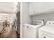 Laundry room with modern washer and dryer, white cabinets, and an archway leading into the kitchen at 349 N Bar Ct., Myrtle Beach, SC 29579