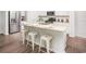 Stylish kitchen with white cabinetry, stainless steel appliances, granite countertops, and an island with stool seating at 378 Ladyfish Loop, Sunset Beach, NC 28468