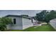 Exterior angle view of mobile home featuring light gray siding and a wooden porch with traditional railings at 3802 Stern Dr., Conway, SC 29526