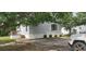 Angle view of mobile home showing gray siding, traditional rails, and a concrete driveway, with a white SUV partially visible at 3802 Stern Dr., Conway, SC 29526