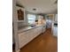 A full shot of the kitchen with white appliances and cabinets, a wooden floor and blue walls with white trim at 3802 Stern Dr., Conway, SC 29526