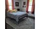 Bedroom featuring a metal bed frame, striped bedding, windows with blinds, and artwork hanging on the wall at 402 Gibson St., Marion, SC 29571