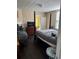Bedroom featuring a four-poster bed, dark wood floors, and neutral walls with a glimpse into a yellow-painted room at 402 Gibson St., Marion, SC 29571