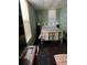 A bedroom with light green walls, hardwood floors, a metal-framed bed, and a desk by the window at 402 Gibson St., Marion, SC 29571