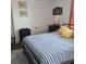 Bedroom featuring a metal bed frame, striped bedding, small nightstand, windows, and artwork hanging on the wall at 402 Gibson St., Marion, SC 29571