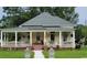 Charming yellow house featuring a welcoming front porch and manicured lawn at 402 Gibson St., Marion, SC 29571