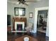 Cozy living room featuring a charming fireplace with a decorative mantle, a ceiling fan, and hardwood floors at 402 Gibson St., Marion, SC 29571