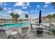 Community pool area with poolside seating, palm trees, and a clear blue sky at 4215 Coquina Harbour Dr. # D -2, Little River, SC 29566