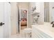 Well-lit bathroom featuring a toilet, shower, and view into connected bedroom at 4709 Wild Iris Dr. # 101, Myrtle Beach, SC 29577