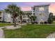 Beautiful condo exterior with stone accents, palm trees and well-manicured lawn at 4709 Wild Iris Dr. # 101, Myrtle Beach, SC 29577
